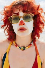 a_beautiful_woman_with_clown_make_up_close_nose_with_a_rainbow_swimsuit_in_beach__with_swim_tube_to_e5u841p27cqz9qhokcj9_0