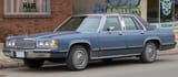 1989_Mercury_Grand_Marquis_GS_Sedan_in_Crystal_Blue_Clearcoat_Metallic,_Front_Left,_11-27-2022