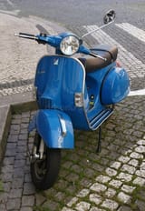 classic-blue-vespa-parked-cobblestone-street-shiny-scooter-european-evoking-sense-timeless-style-urban-adventure-378243814