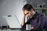 21772355-unhappy-stressed-male-student-looking-at-his-laptop-computer-with-his-head-in-his-hands