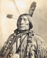 Portrait-of-Chief-Wolf-Robe-with-pipe-and-Benjamin-Harrison-silver-peace-medal-Copyright-13-AUG-1904-smithsonian_scaled
