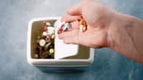 throwing-a-handful-of-pills-in-the-trash-can-3090120276