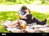 romantic-couple-kissing-on-blanket-at-park-at-sunny-day-2S4W9E4