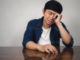 asian-man-sit-at-table-feels-depressed-and-sadness-and-crying-about-life-photo