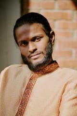 handsome-indian-man-sitting-portrait-handsome-indian-man-dark-chocolate-eyes-dressed-patterned-peach-colored-shirt-326009418