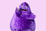 grimace-holding-his-famous-milkshake-on-a-purple-background