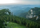Romania Ceahlau mountains - Scenic view of a mountain range with lush green trees