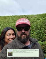 4chan pol australia with ugly masculine trans wife pol - Man with a beard and a red hat stands with a woman in front of a green hedge