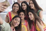 happy-indian-women-and-girls-in-saris-taking-selfie-CAIF29010