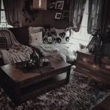 a-catchy-moody-living-room-done-with-a-monochromatic-color-scheme-with-grey-curtains-a-wooden-table-printed-pillows