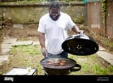 black-man-grilling-hamburgers-at-backyard-barbecue-F2NHDE-1708080446