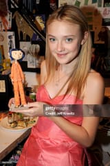 Dakota Fanning, holding a model of Coraline at The Premiere