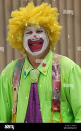 portrait-of-a-clown-with-silver-tooth-smiling-waring-yellow-wig-fluorescent-DYE6P3