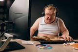 154109295-drunk-man-sitting-at-home-with-computer-looking-depressed-alcohol-addiction-problem-concept-close