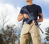 59797425-man-with-trees-behind-with-an-ar-15-and-a-pistol-on-his-side