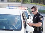 woman-getting-ticket-from-police-officer-gettyimages-1200-1024x754
