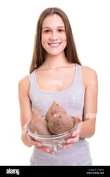 young-woman-holding-some-sweet-potatoes-isolated-over-white-background-P7R30K