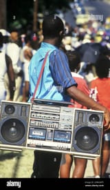 austin-texas-usa-june-1989-young-black-man-carries-large-boombox-on-a-shoulder-strap-while-watching-a-parade-bob-daemmrich-2HM2WF5