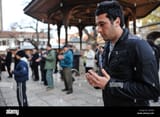 a-young-bosnian-muslim-man-prays-in-front-husrev-beys-mosque-in-sarajevo-CEXYF8