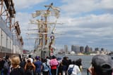 People watch the Mexican Navy training vessel Cuauhtemoc with broken masts while docked at a pier, after striking the Brooklyn Bridge overnight