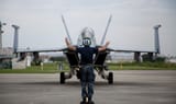 aviation_structural_mechanic_3rd_class_steven_brittel__signalling_an_f_a_18f_super_hornet_at_naf_atsugi__japan