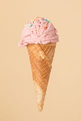 cornet-ice-cream-with-strawberry-scoop-colorful-surface