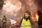 french-yellow-vest-protestor-wearing-guy-fawkes-mask-demonstration-paris-front-fire-france-november-149156175