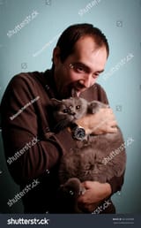 stock-photo-young-man-holds-and-licks-a-gray-cat-561650989