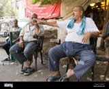 fat-man-gesticulating-in-street-cafe-cairo-egypt-B4KA71