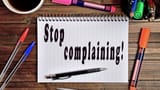 the-words-stop-complaining-written-on-a-notebook-paper
