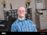 man-with-down-syndrome-working-in-an-office-2A92YH4