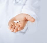 depositphotos_78104760-stock-photo-doctor-hands-giving-white-pills