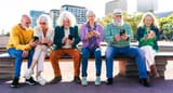 aldre-personer-sitter-pa-pank-mobiltelefoner-1024x552