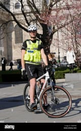 a-british-police-officer-in-uniform-on-push-bike-on-patrol-london-DWPPR8-46089381