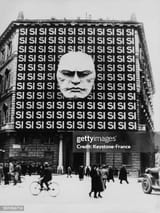 italian-plebiscite-board-with-si-and-mussolini-portrait-on-the-facade-of-a-building-on-march-806422341