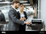 business-man-and-woman-talking-near-the-copier-during-a-coffee-break-in-the-hallway-of-the-big-corporation-2AA2390