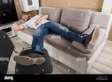 young-man-sleeping-on-couch-in-living-room-KYJ4Y7-3117241928