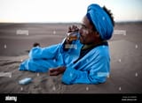 nomad-berber-drinking-tea-in-the-sahara-desert-erg-chigaga-morocco-CRG3W5