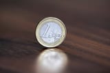 111680890-am-rand-steht-eine-münze-im-wert-von-einem-euro