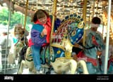 down-syndrome-woman-age-32-giving-thumbs-up-on-carousel-st-paul-minnesota-AW6MFC