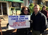 Comet-Ping-Pong-Support-event-couple-with-sign-1672x1254