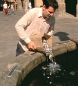 Man dumping cents in fountain