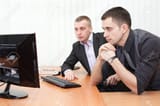 12081636-two-business-men-looking-together-at-computer-screen-in-office