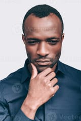 lost-in-thoughts-thoughtful-young-african-man-holding-hand-on-chin-and-looking-away-while-standing-against-grey-background-photo