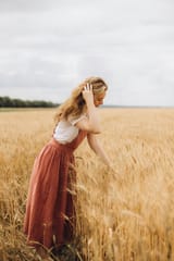 free-photo-of-woman-in-a-red-dress-in-a-grain-field