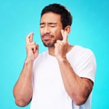 praying-hope-man-fingers-crossed-anxiety-nervous-due-crisis-stress-isolated-studio-blue-background-fear-suspense-young-male-person-hands-face-mistake-risk-reaction_590464-212467