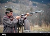 a-hunter-with-a-gun-in-his-hands-in-hunting-clothes-takes-aim-and-is-ready-to-shoot-2F3R4GX