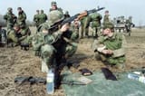 US IFOR Sergeant Daniel MOODY of Springfield, Missouri, plays with a Russian AK assault rifle at lunchbreak the joint US:Russian artillery training exercice outside the village of Koraj in the Serb entity on March 10, 1996