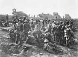 September_29_1918_American_Soldiers_of_the_30th_Infantry_Division_attached_to_British_Army_1st_Australian_Corps_with_German_prisoners_after_the_capture_of_Bellicourt_note_SMLE_MkIII_rifles_and_British_MkV_tanks_behind