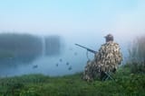 waterfowl-hunter-with-gun-a-hunter-in-camouflage-hunting-on-ducks-in-summer-or-autumn-season